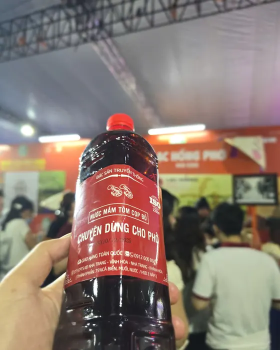 Chai Tôm Cọp Đỏ giơ cao giữa đông người trong lều lễ hội